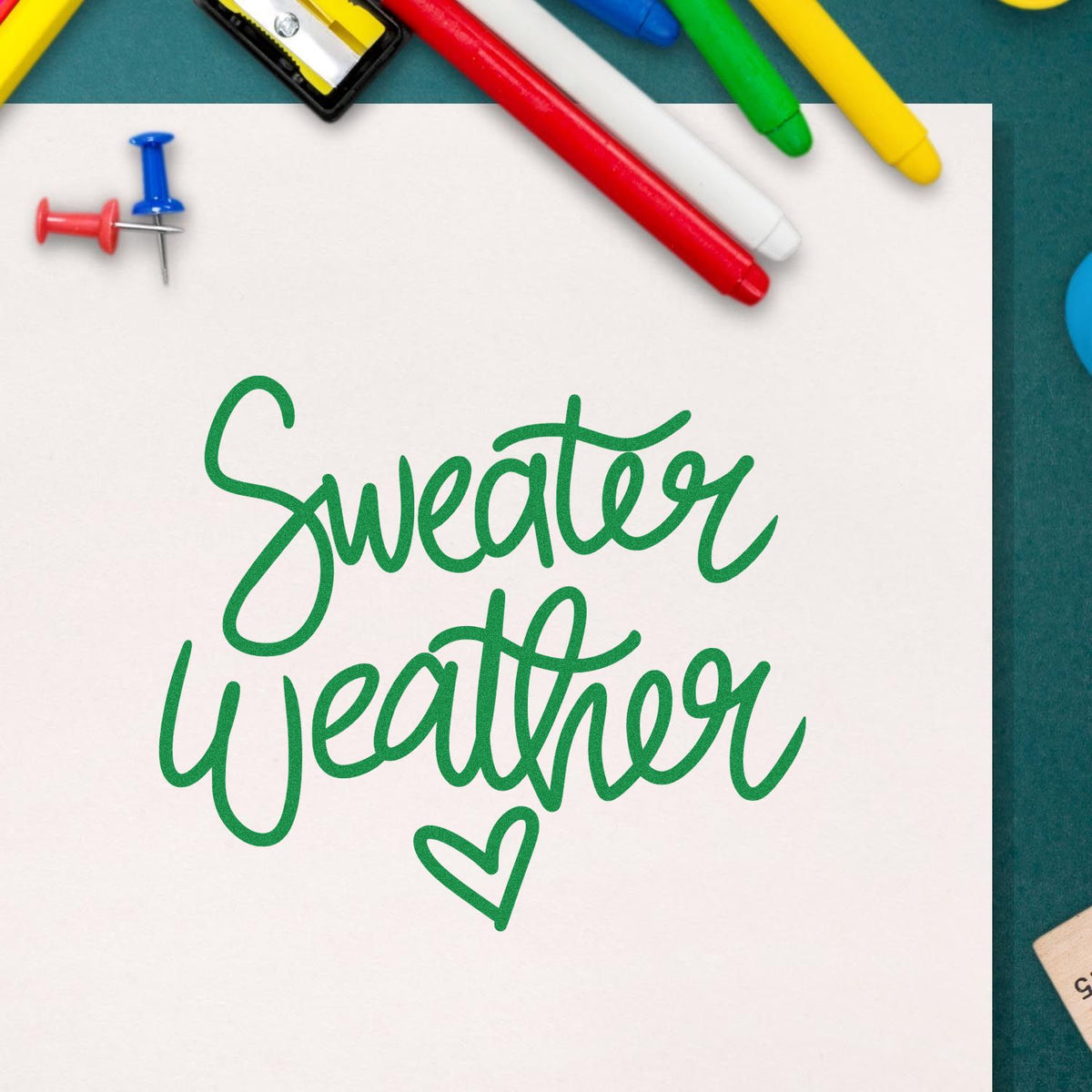 Custom rubber stamp design with green Sweater Weather script and heart, perfect for fall craft projects and seasonal stationery.