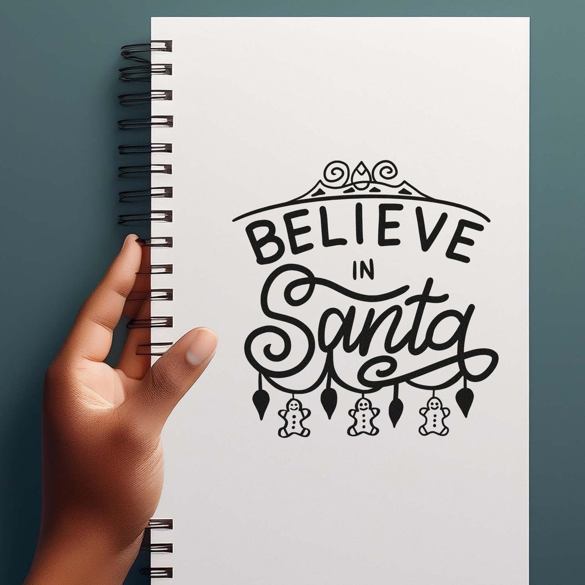 Believe in Santa rubber stamp mockup on notebook, perfect for Christmas cards, holiday crafts, and festive scrapbooking.