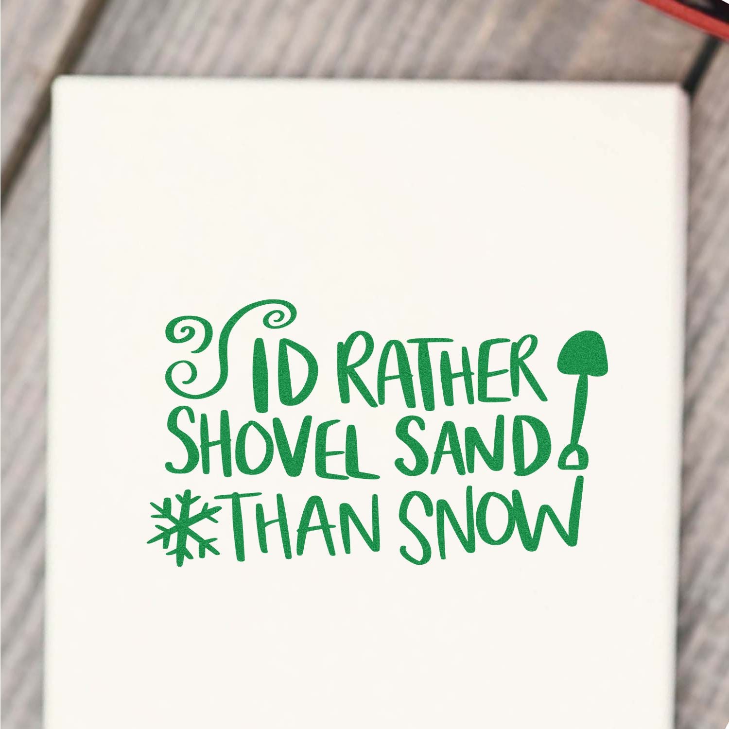 Humorous custom rubber stamp design reading Id rather shovel sand than snow with shovel and snowflake icon.