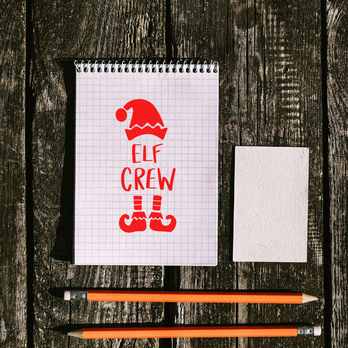 Holiday elf crew rubber stamp design mockup with Santa hat and festive lettering for Christmas cards and crafts.