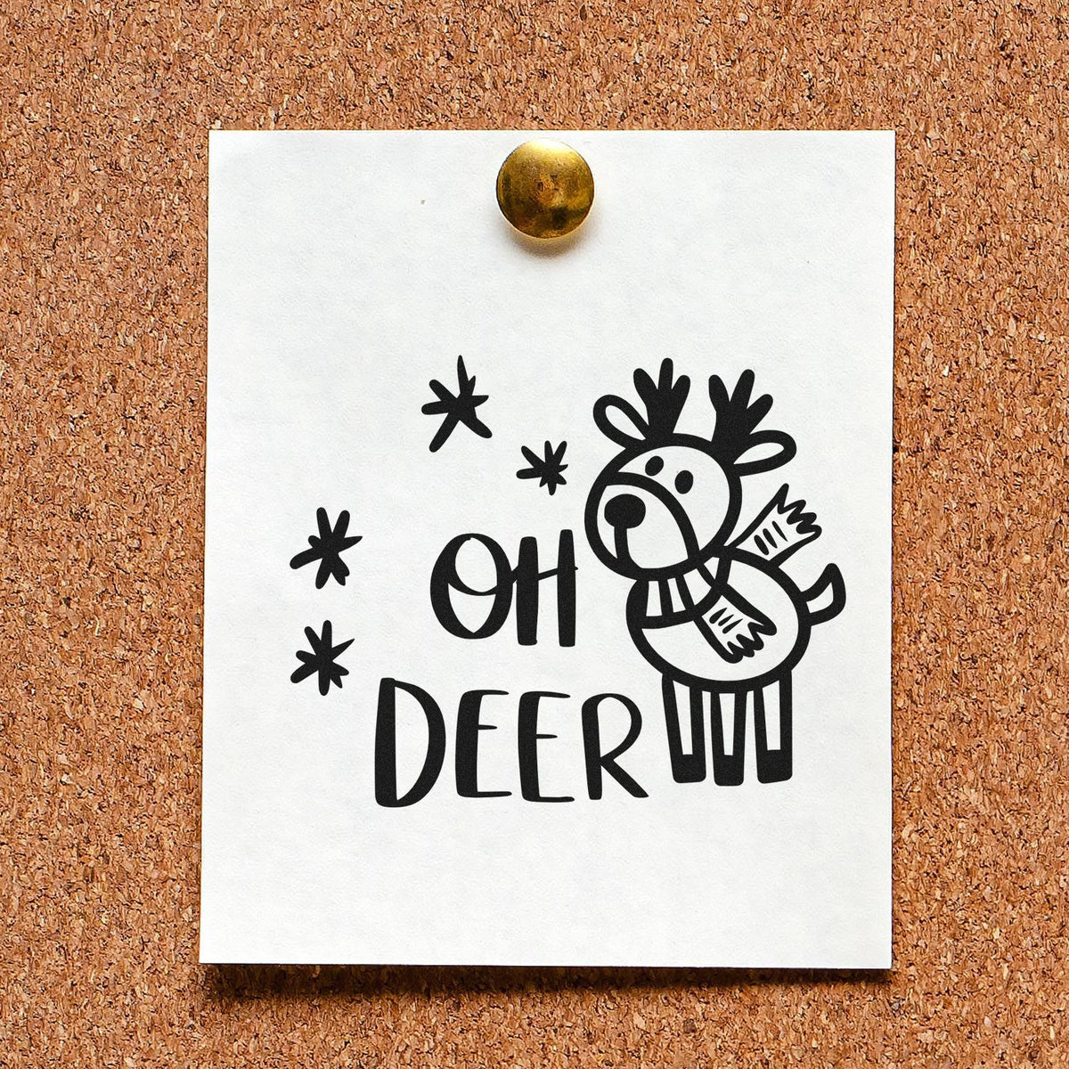 Reindeer rubber stamp design with Oh Deer holiday pun and snowflake accents on pinned white paper.