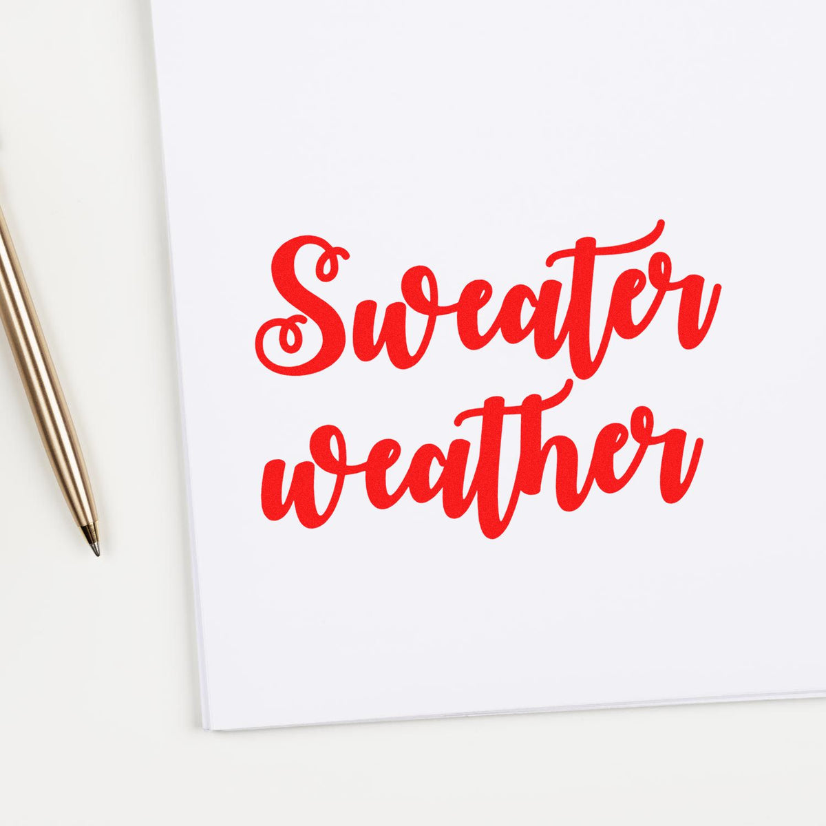 Sweater weather rubber stamp design in bold red script on white paper, ideal for seasonal crafting and holiday card making