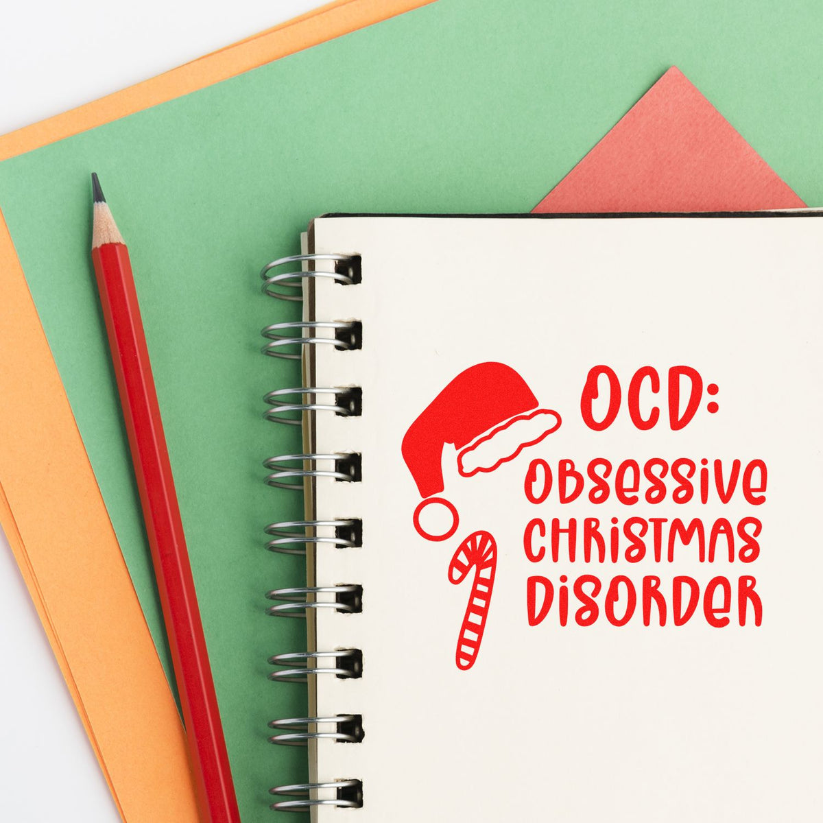Christmas rubber stamp design with Santa hat and candy cane reading OCD: Obsessive Christmas Disorder in a notebook.