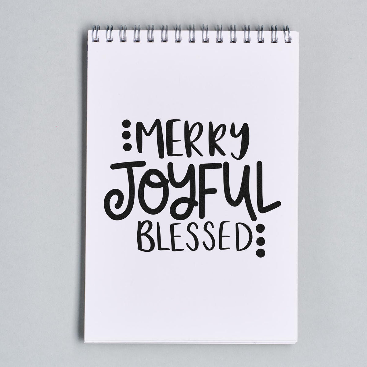 Merry Joyful Blessed Christmas rubber stamp design on a spiral notebook.