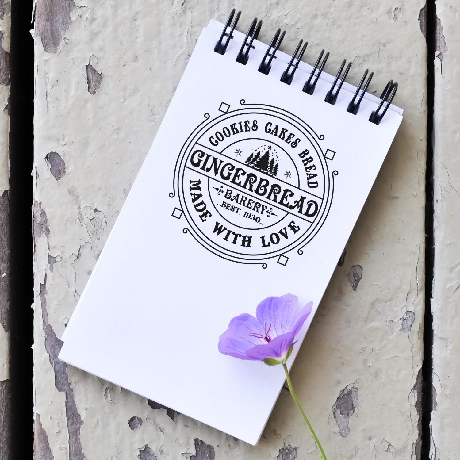 Custom gingerbread bakery rubber stamp mockup on spiral notebook, featuring Cookies Cakes Bread Made With Love.