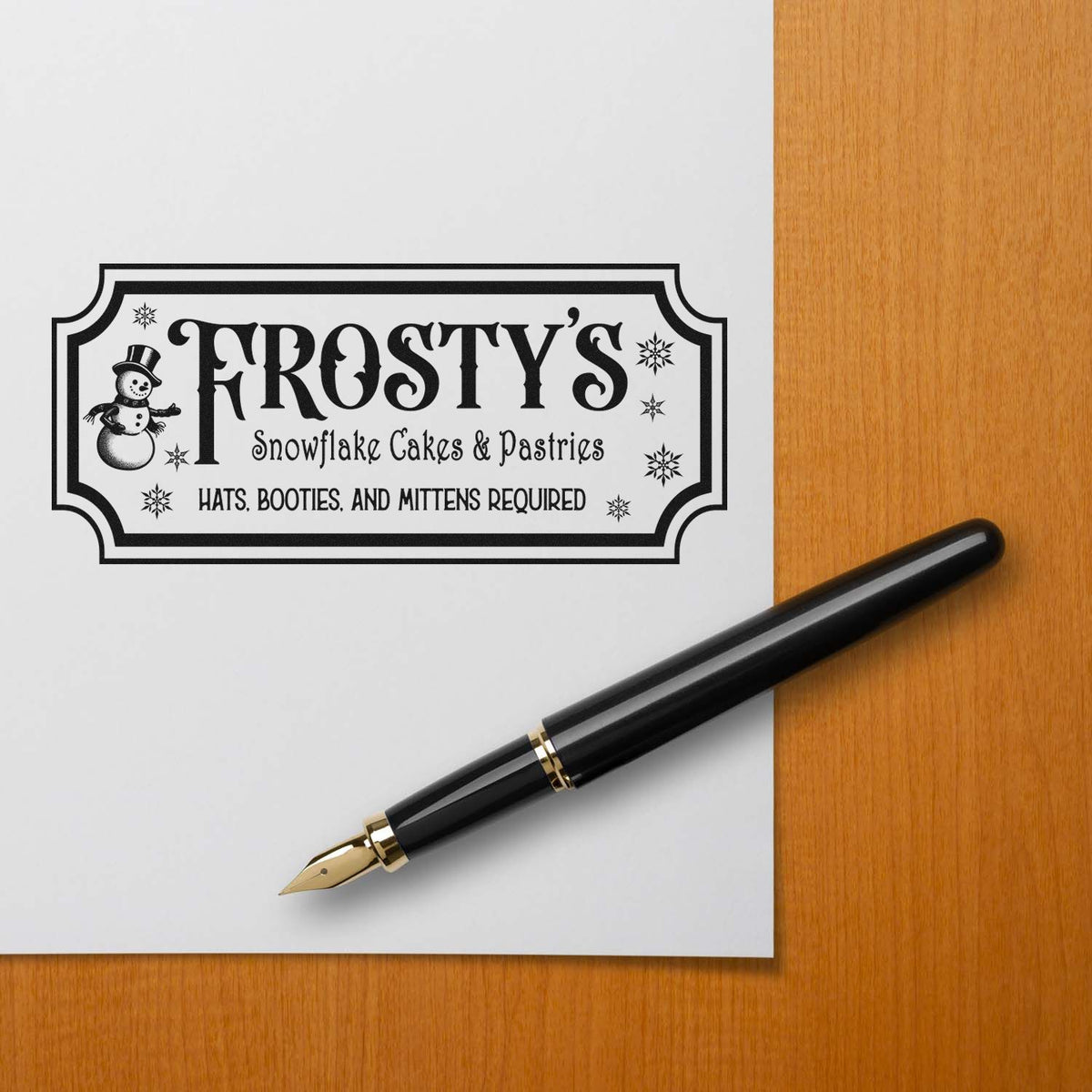 Custom rubber stamp for Frostys Snowflake Cakes & Pastries bakery logo with snowman and winter design.