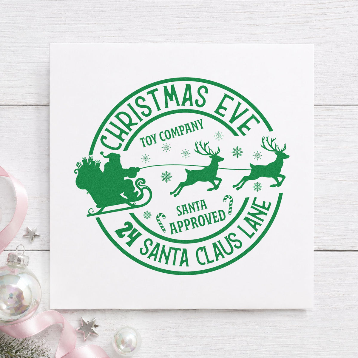 Christmas Eve Toy Company craft stamp imprint in green ink on a handmade project, one idea being shipping slip cards.