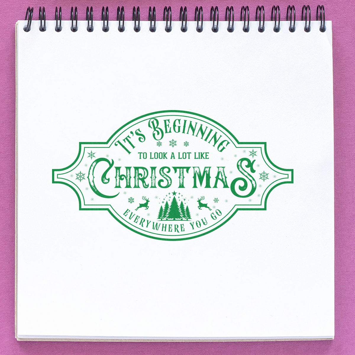 Vintage Christmas rubber stamp design reading Its Beginning to Look a Lot Like Christmas Everywhere You Go in green lettering.