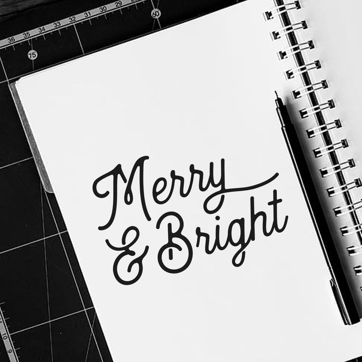 Merry & Bright holiday rubber stamp design on notebook, perfect for festive card making and craft projects.