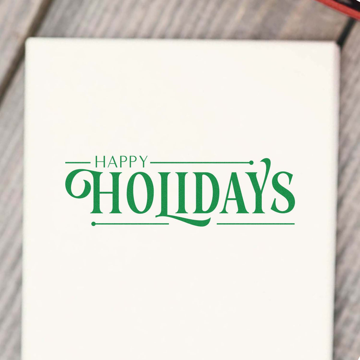Green Happy Holidays rubber stamp on white paper for festive greeting cards, gift wrap, and holiday packaging.