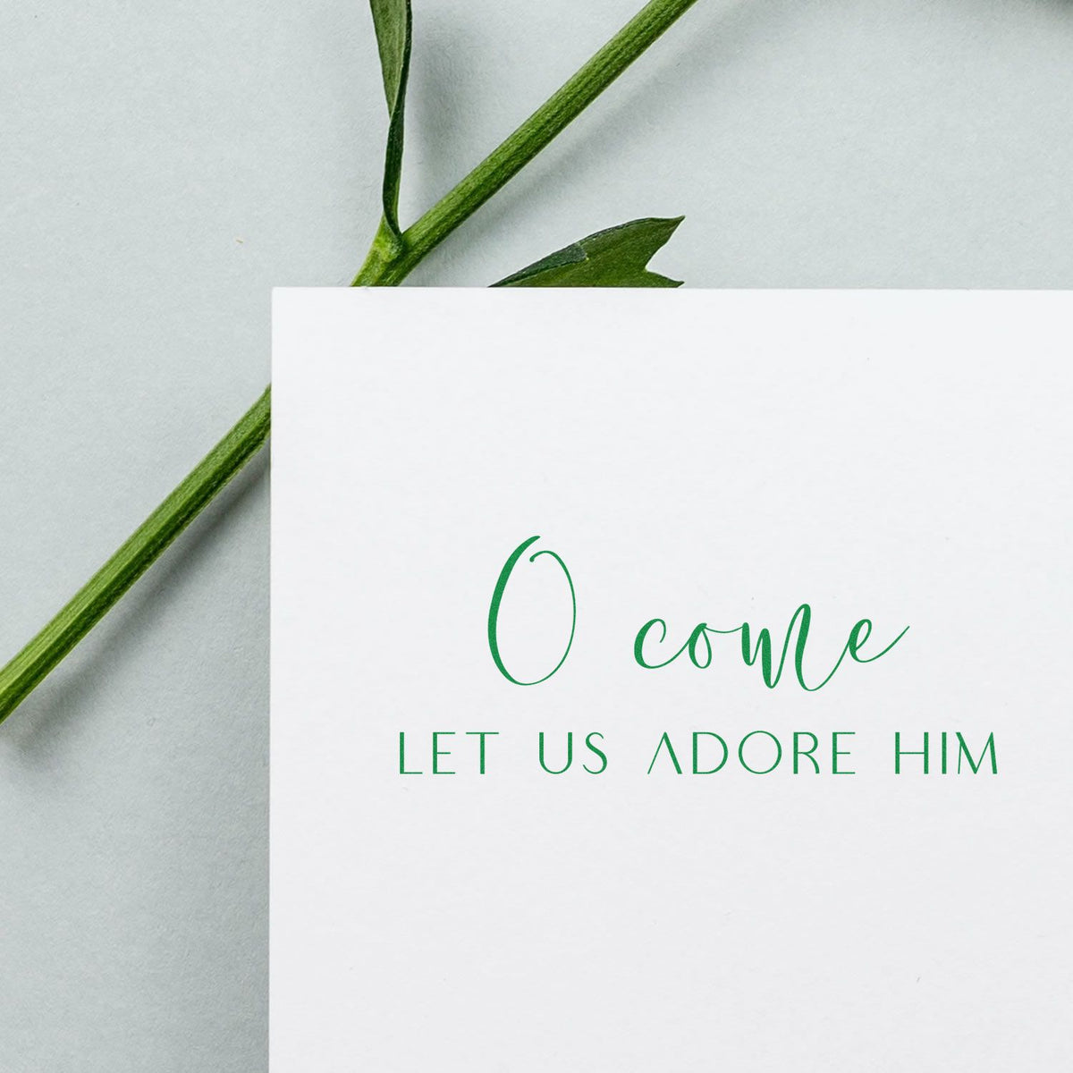 O Come Let Us Adore Him Christmas rubber stamp design for handmade holiday cards, with elegant green script and greenery.
