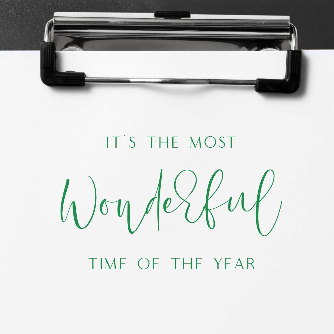 Holiday rubber stamp design reading Its the most wonderful time of the year in green script on paper.