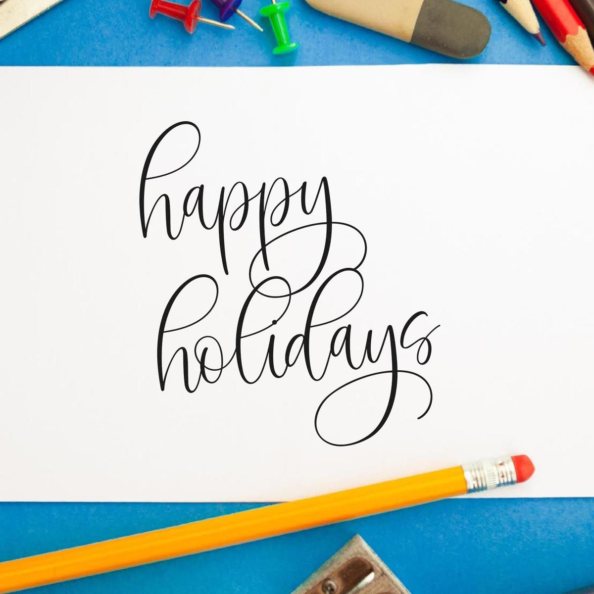 Happy Holidays Flourished Calligraphy Script Lettering PSI Pre-Inked Stamp imprint stamped in black ink. The words "happy holidays" appear in two lines of thin script with large looping flourishes.