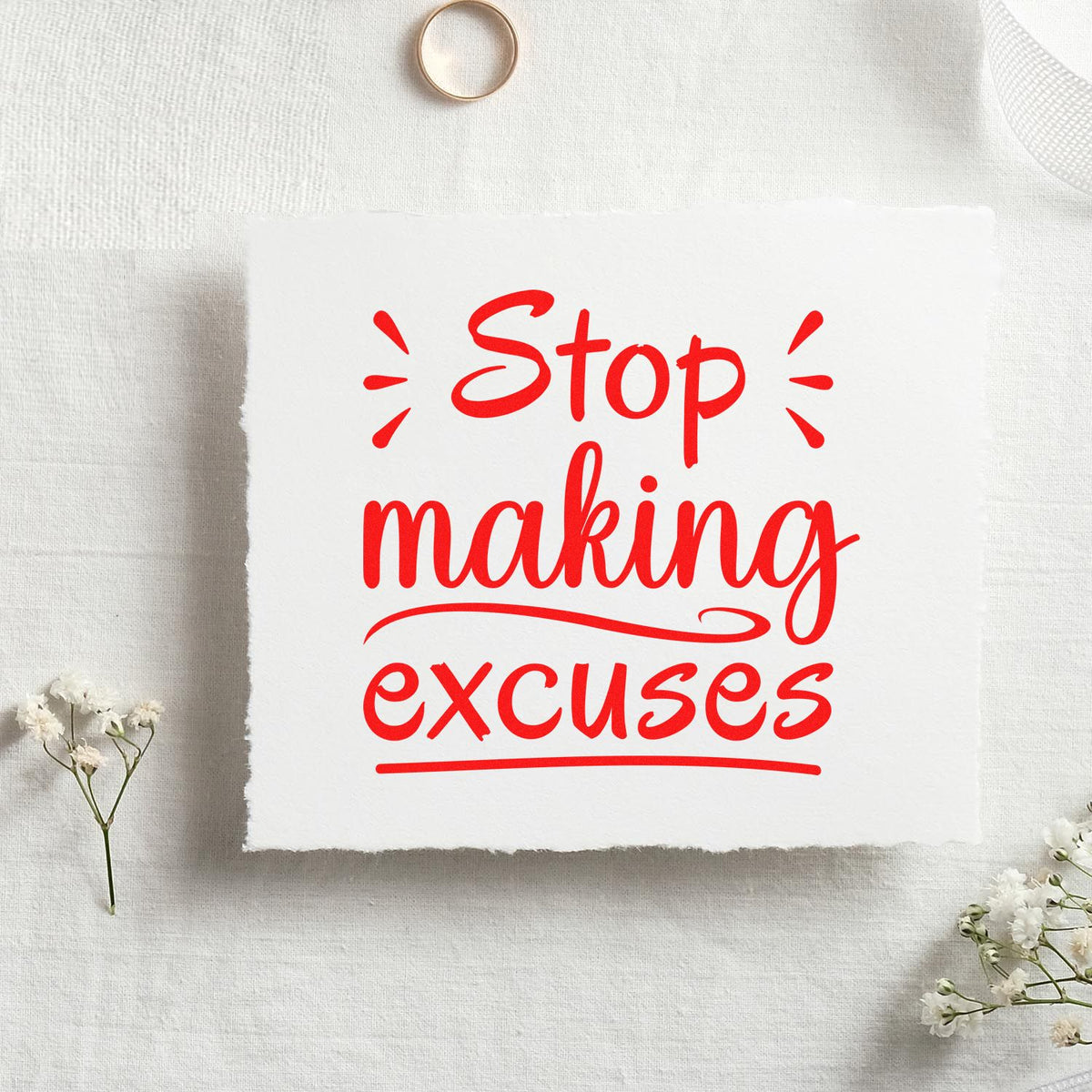 Custom rubber stamp design with red Stop making excuses quote on white fabric, ideal for motivational craft projects.