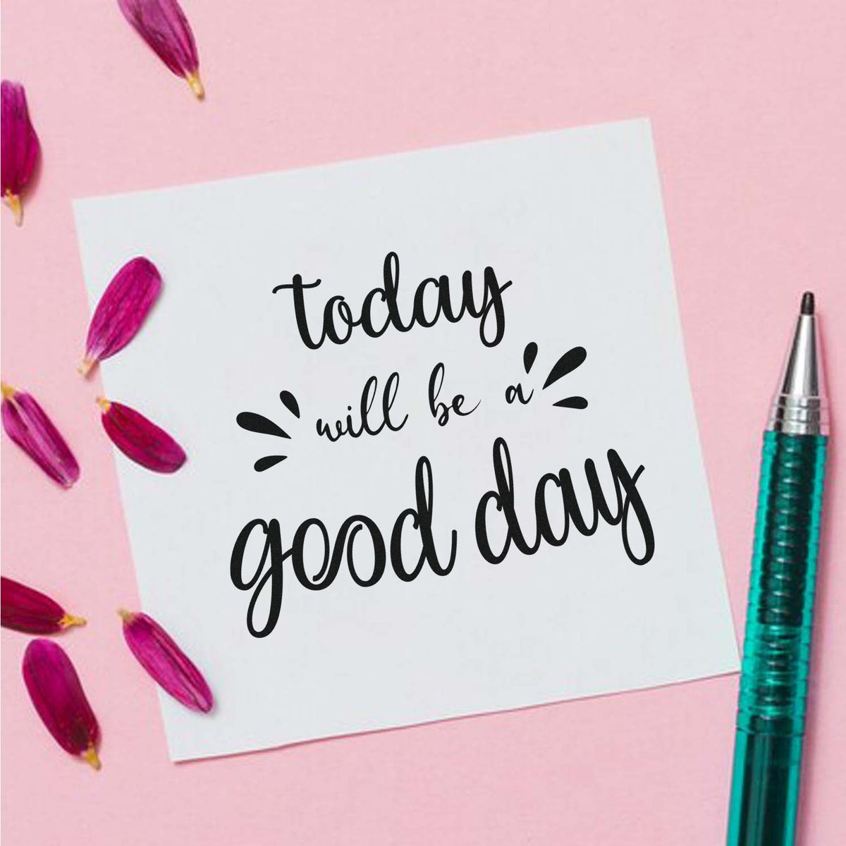 Motivational rubber stamp design reading today will be a good day on white card with pink petals and pen.