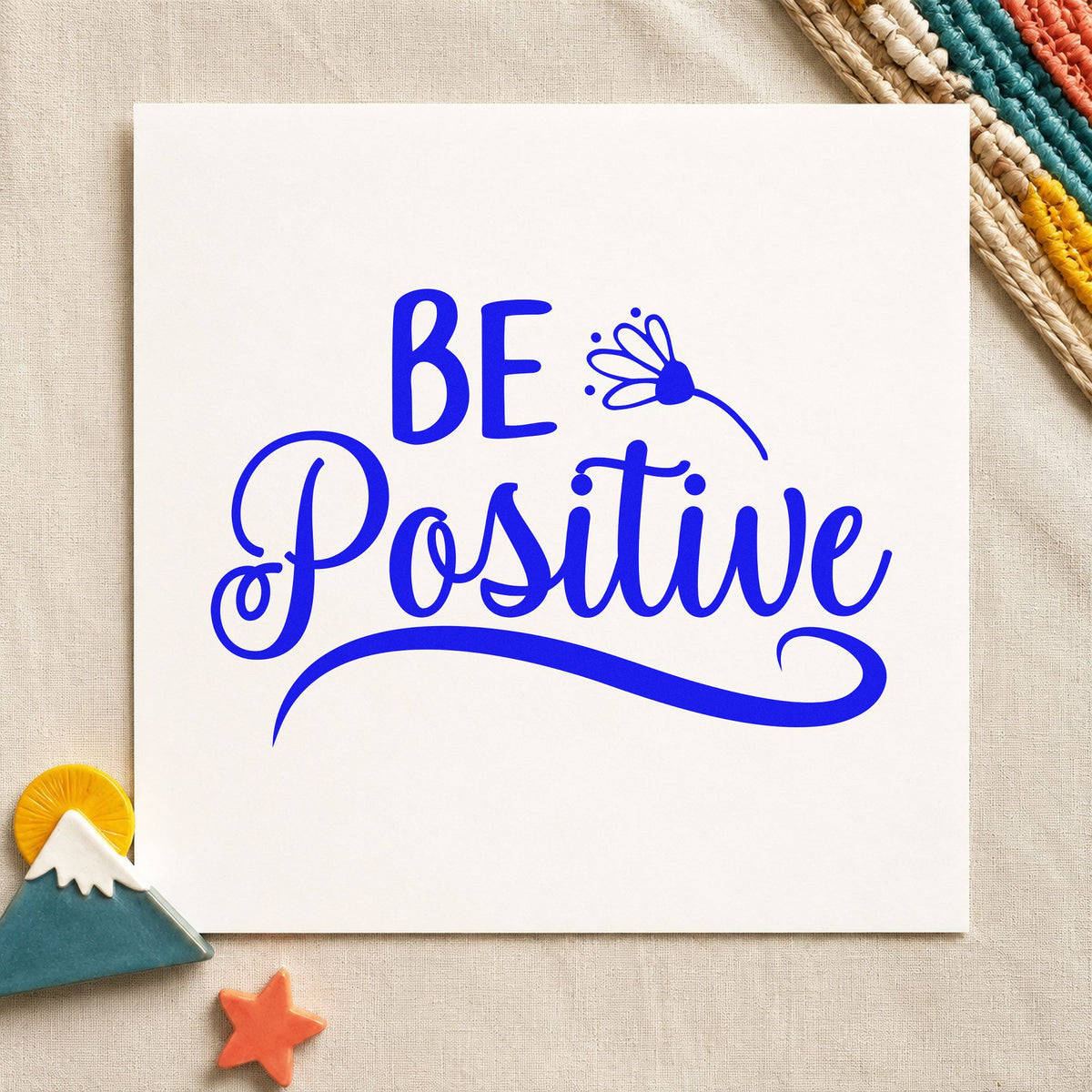 Be Positive Flower Script craft stamp imprinted in blue ink on paper, a design suited to framed shop window.