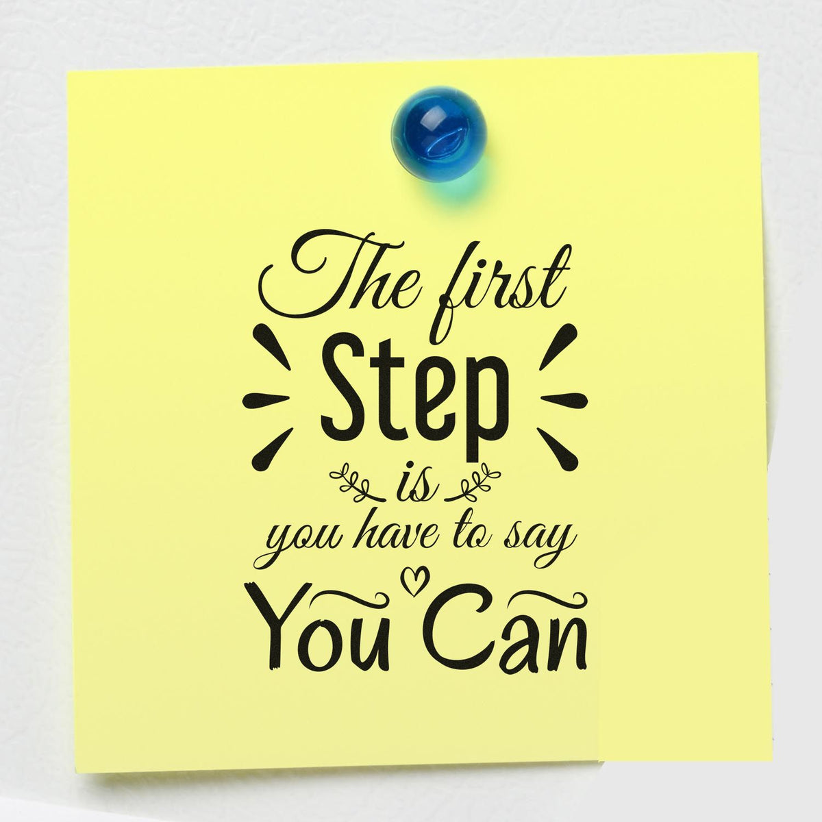 Inspirational rubber stamp design on yellow sticky note with quote The first step is you have to say you can pinned with blue tack.