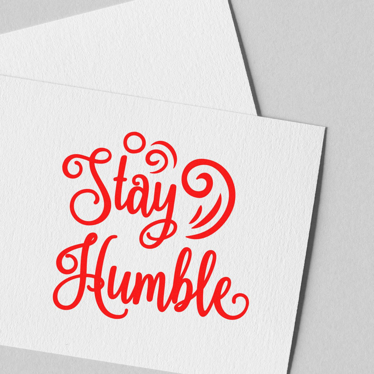 Red Stay Humble calligraphy rubber stamp design on textured paper