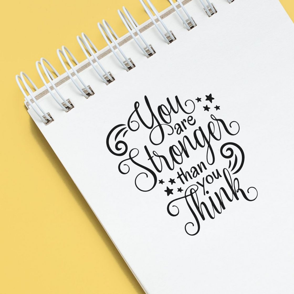 Inspirational rubber stamp quote, You are stronger than you think, on a spiral notebook for crafting and journaling.