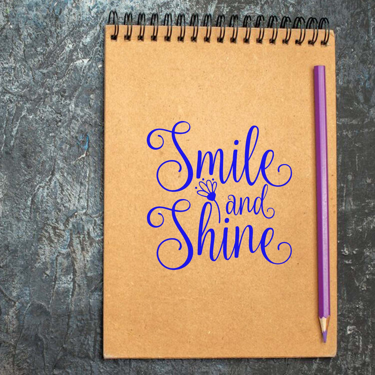 Smile and Shine script rubber stamp design on notebook with pencil, inspirational crafting sentiment.