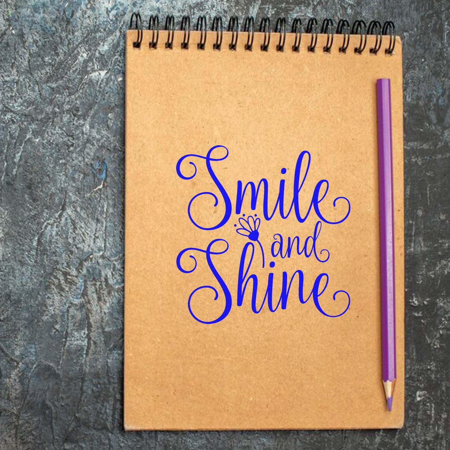 Smile and Shine decorative rubber stamp design on spiral notebook with pencil, ideal for motivational crafts and stationery.