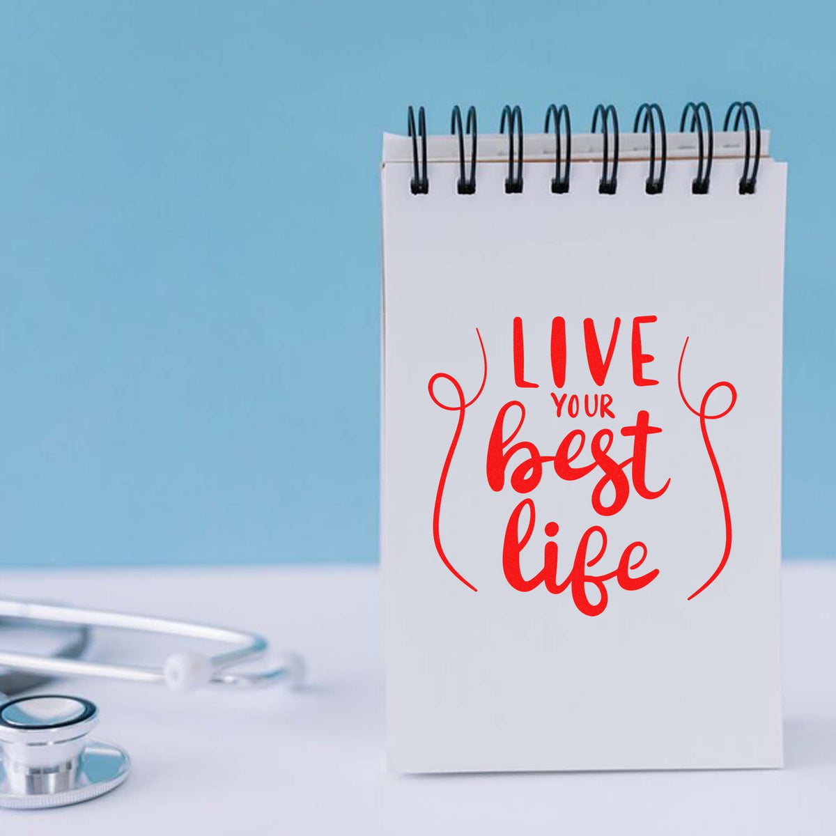 Custom rubber stamp design with red Live Your Best Life lettering on a notebook, perfect for motivational branding and planners.
