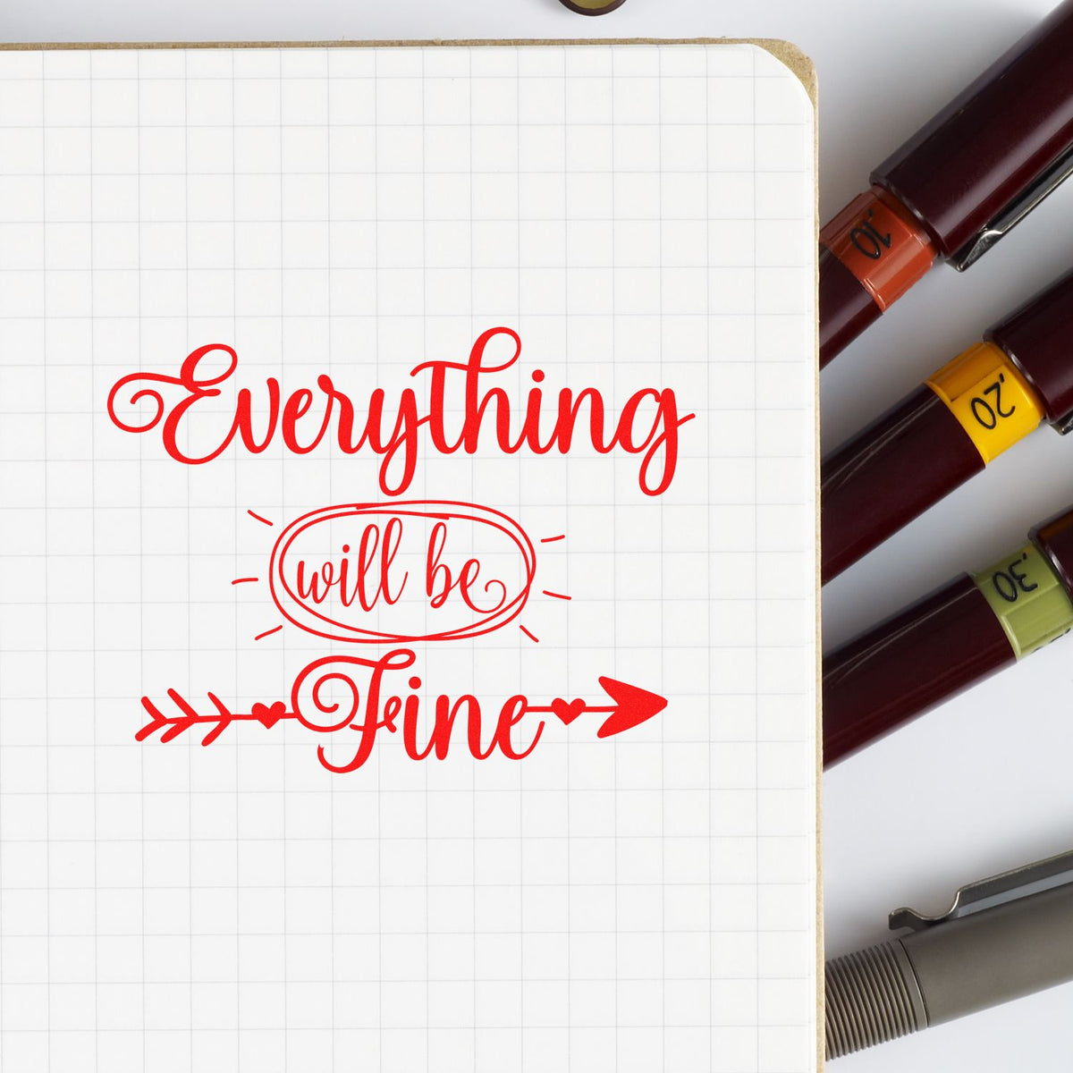 Motivational rubber stamp design reading Everything will be fine on notebook, with colored stamp markers on the side.
