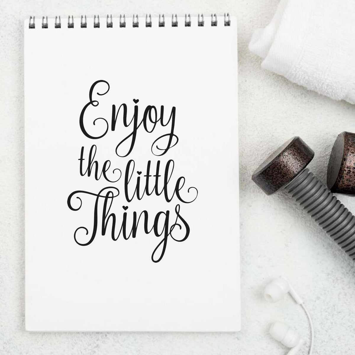 Custom rubber stamp design with Enjoy the little things script quote on notebook mockup for inspirational crafts.