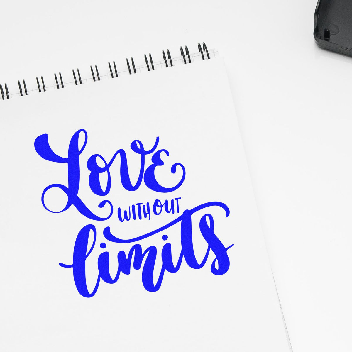 Blue Love Without Limits rubber stamp design on a notebook page, ideal for custom inspirational stamps.