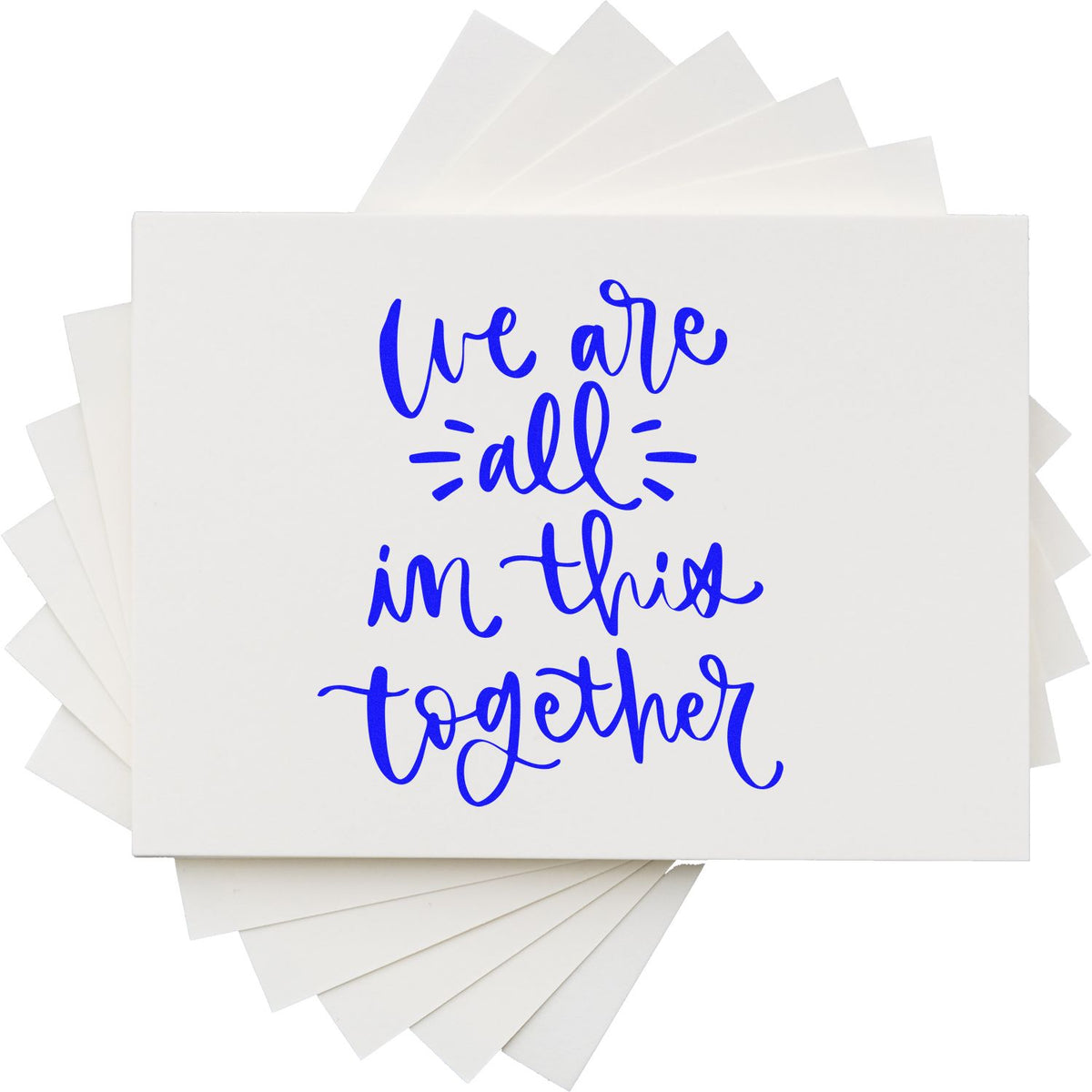 Custom rubber stamp design reading We Are All in This Together in blue script on stacked white cards.