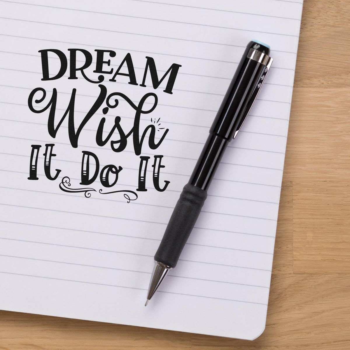 Dream Wish It Do It rubber stamp on lined notebook with pen, ideal for planners, journaling, and motivational crafts.