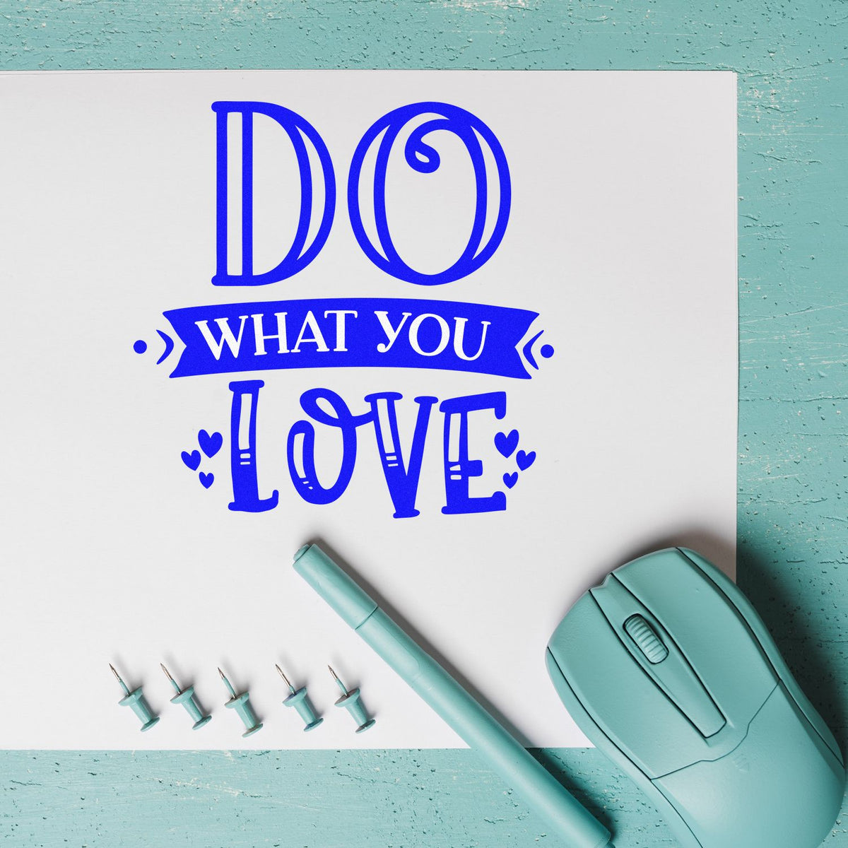 Custom rubber stamp design reading Do What You Love with blue lettering, carving tools, and a stamp maker on teal background.