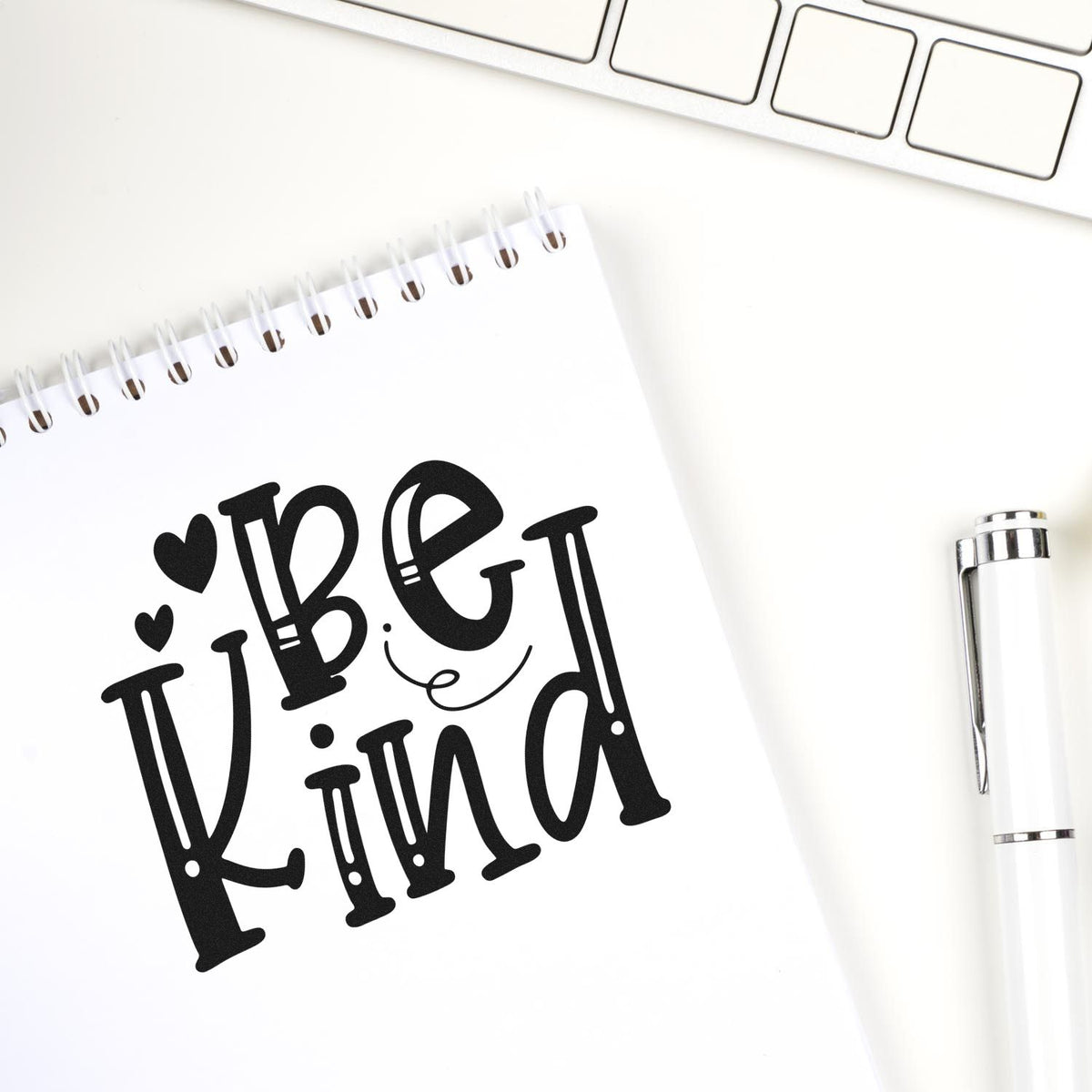 Be Kind rubber stamp design on notebook, featuring a decorative motivational phrase for journaling, planners, and stationery.