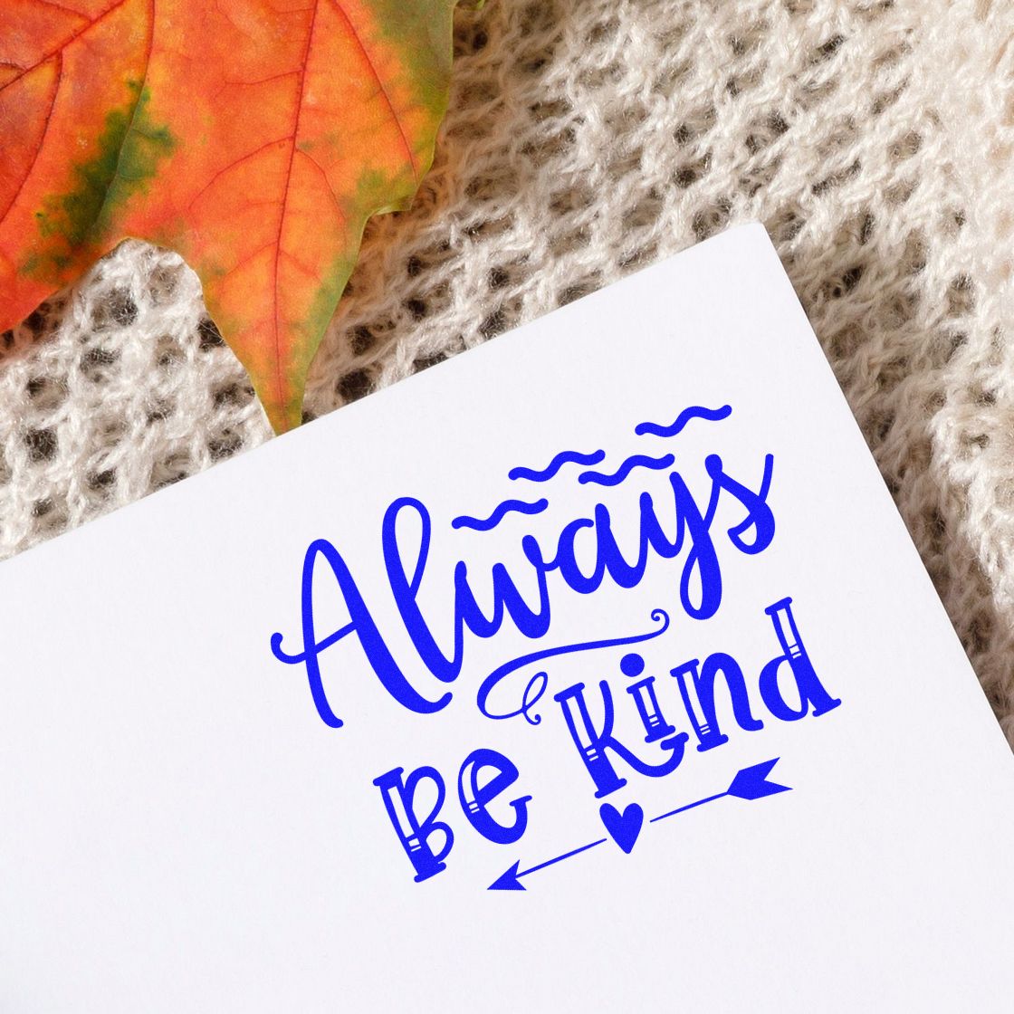 Always Be Kind custom rubber stamp design in blue on white paper, styled with leaf and knit background.