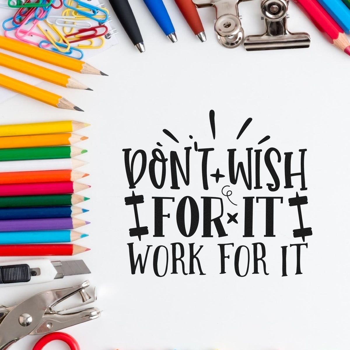 Motivational custom rubber stamp quote, Dont Wish for It, Work for It, with pencils, paper clips, and office supplies.