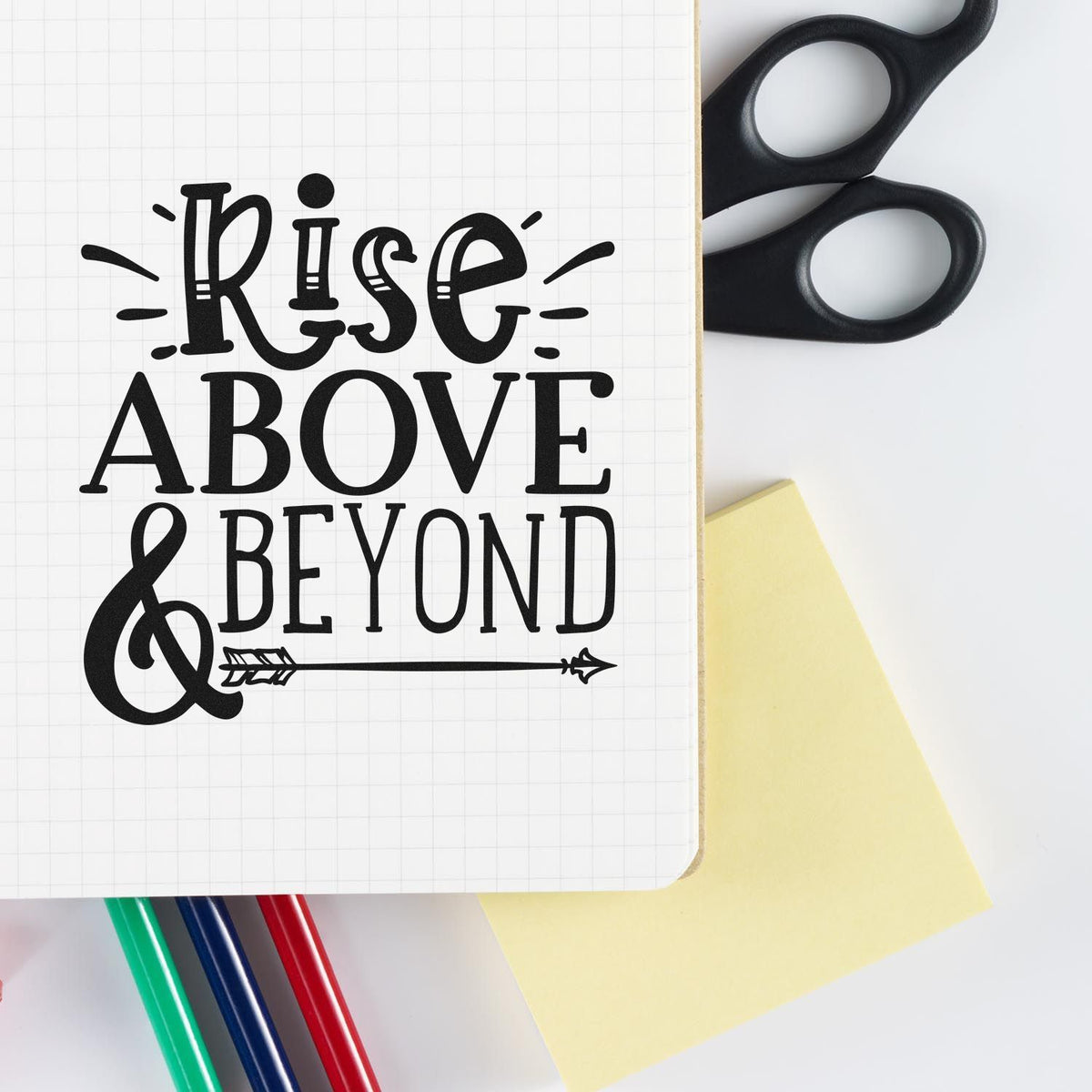 Rise Above & Beyond rubber stamp design on notebook page, ideal for motivational journaling, planners, and craft projects.
