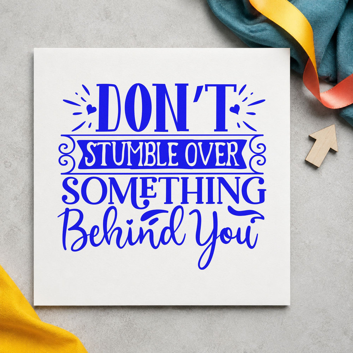 Don't Stumble Over Behind You craft stamp in blue ink on cardstock, an easy option for tote panel printing.