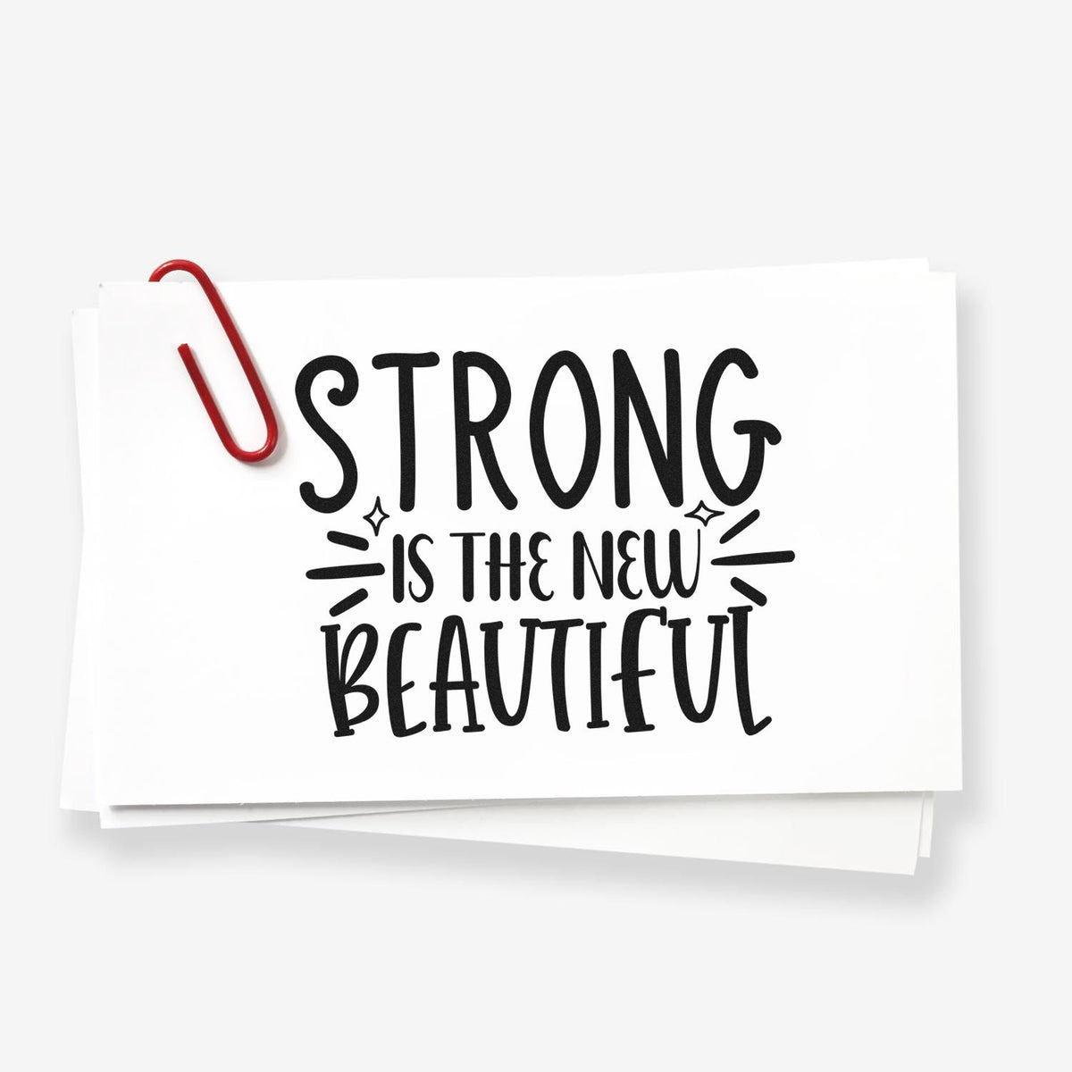 Strong New Beautiful Lettering Stamp - Premium Vintage Pro Wooden imprint stamped in black ink. The phrase "Strong is the new beautiful" appears in stacked hand lettering with emphasis marks.