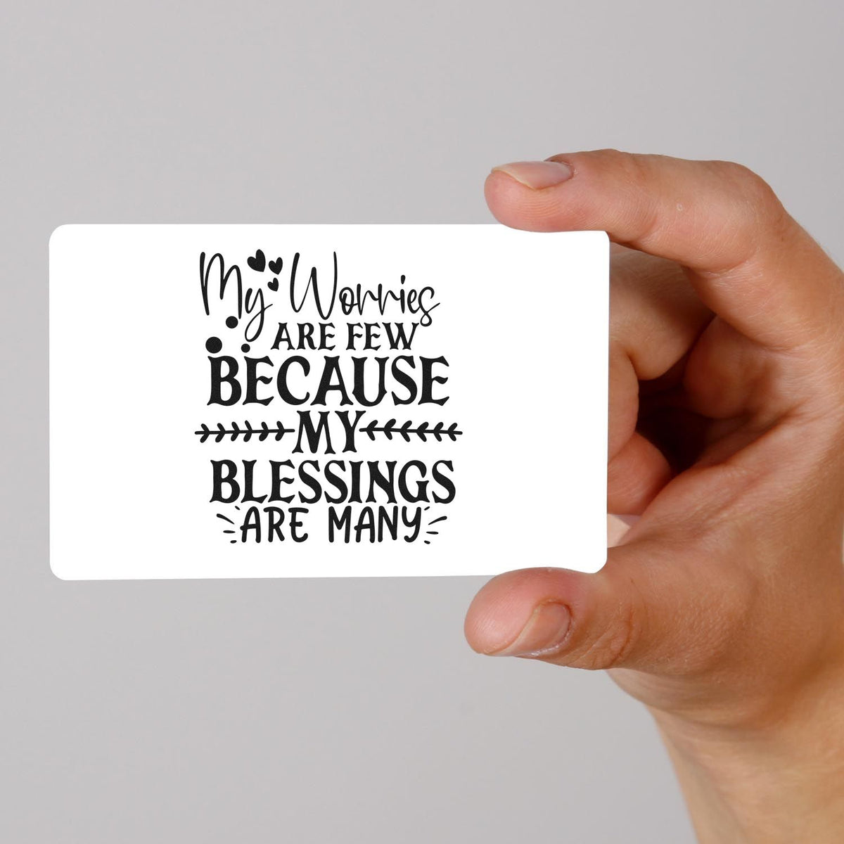 Hand holding a faith-inspired rubber stamp design reading My worries are few because my blessings are many.