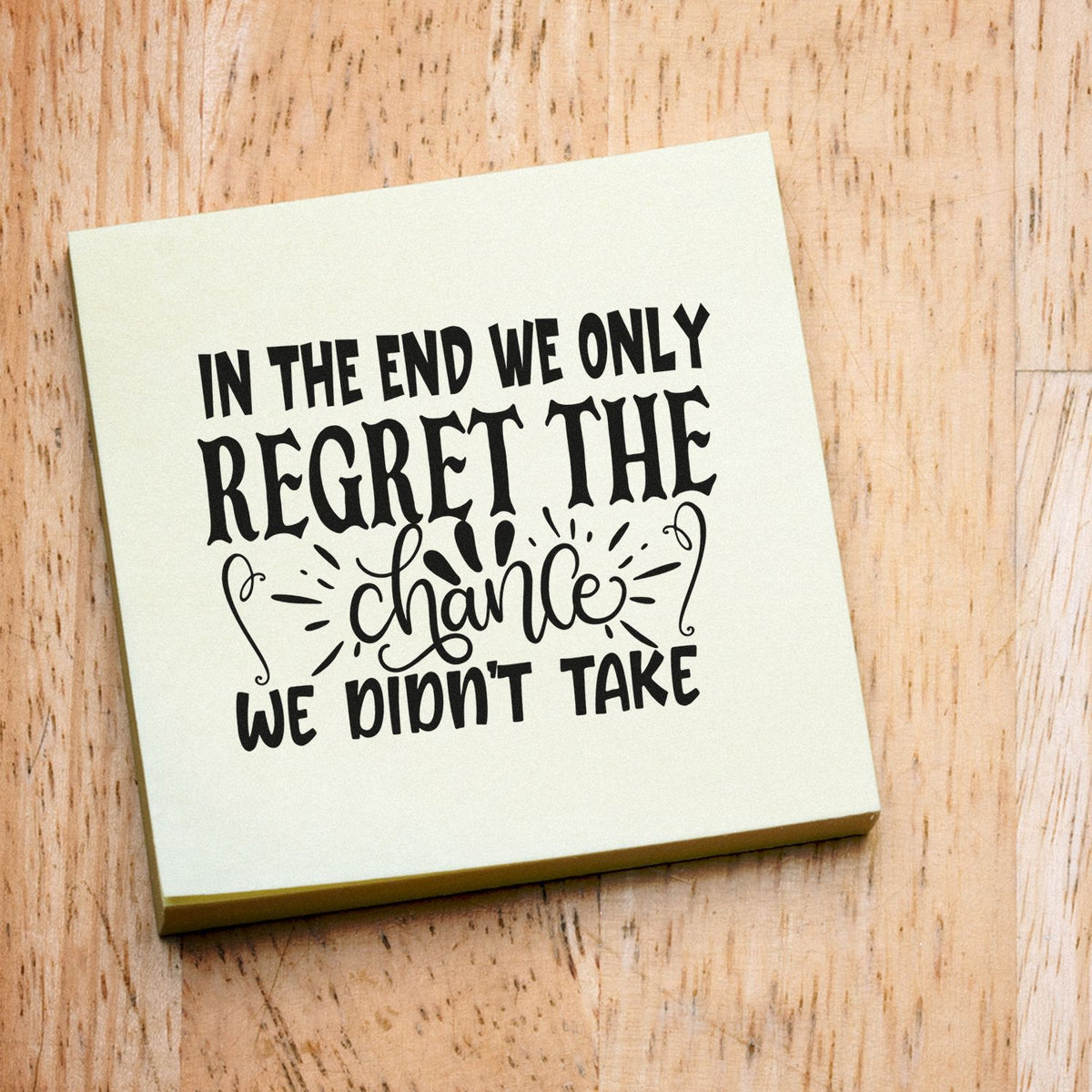Custom rubber stamp with inspirational quote, In the end we only regret the chance we didnt take, on a wooden block.