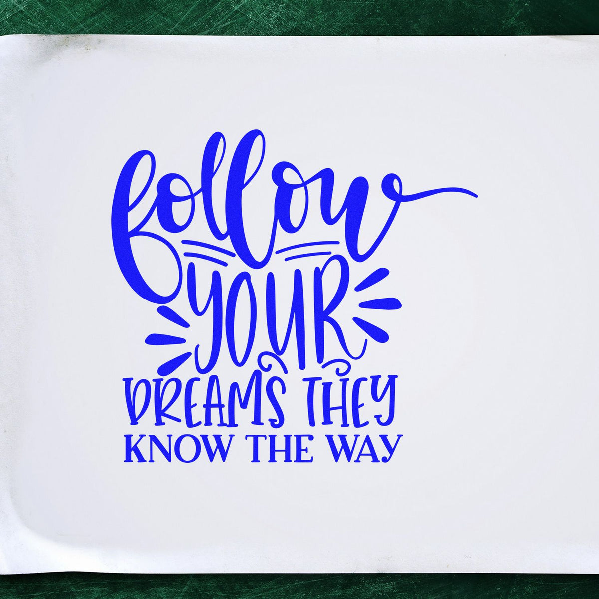 Custom rubber stamp design with motivational quote, Follow Your Dreams, They Know the Way, in blue lettering.