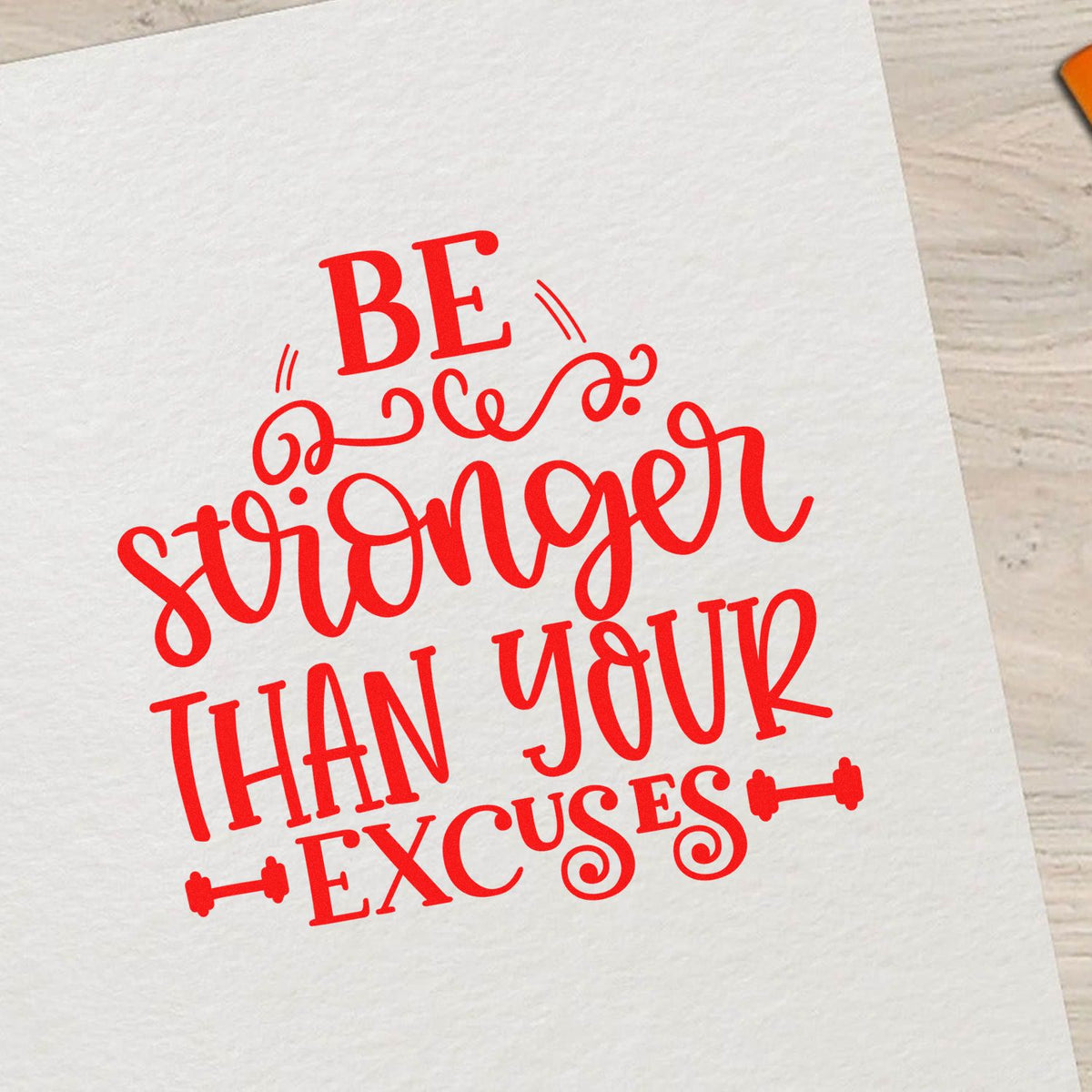 Motivational rubber stamp design reading Be stronger than your excuses in bold red script on white paper.