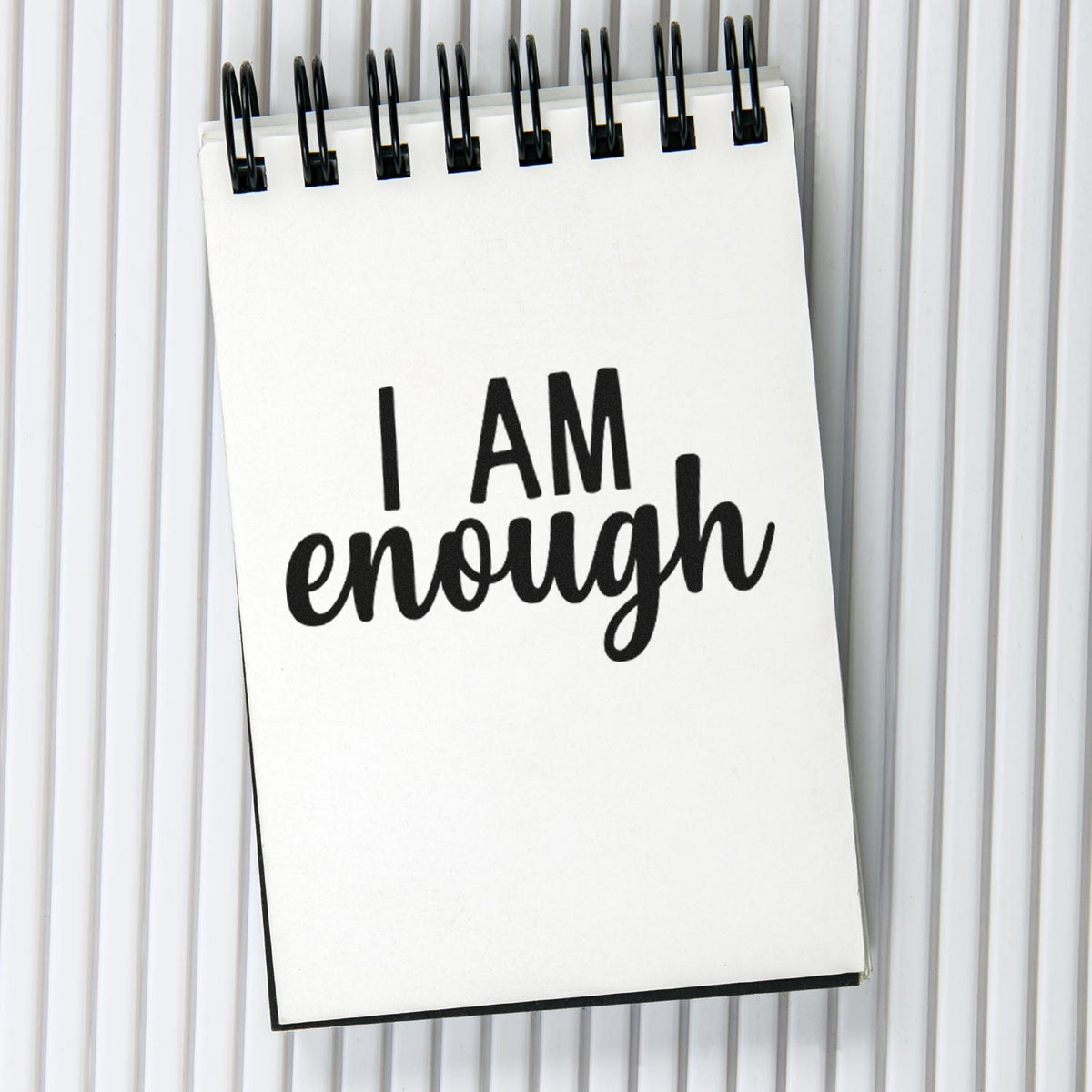 Inspirational I Am Enough rubber stamp design on a notepad, ideal for journaling, crafting, and motivational office decor.