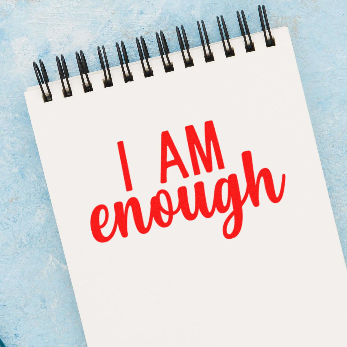 I AM enough motivational rubber stamp on a notebook page for self-love, affirmation, and journaling.