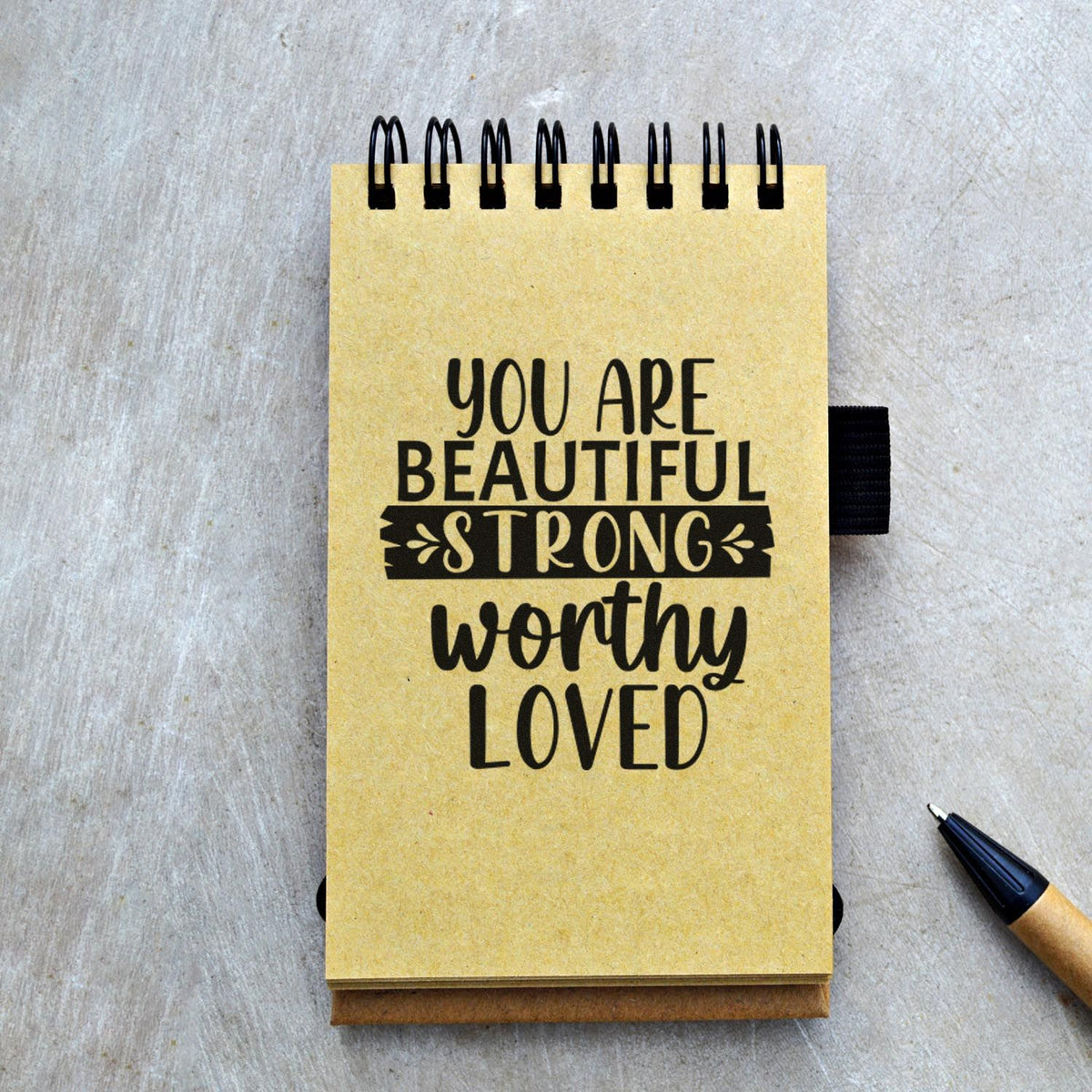 Inspirational encouragement rubber stamp design on a spiral notebook with the message You Are Beautiful, Strong, Worthy, Loved.