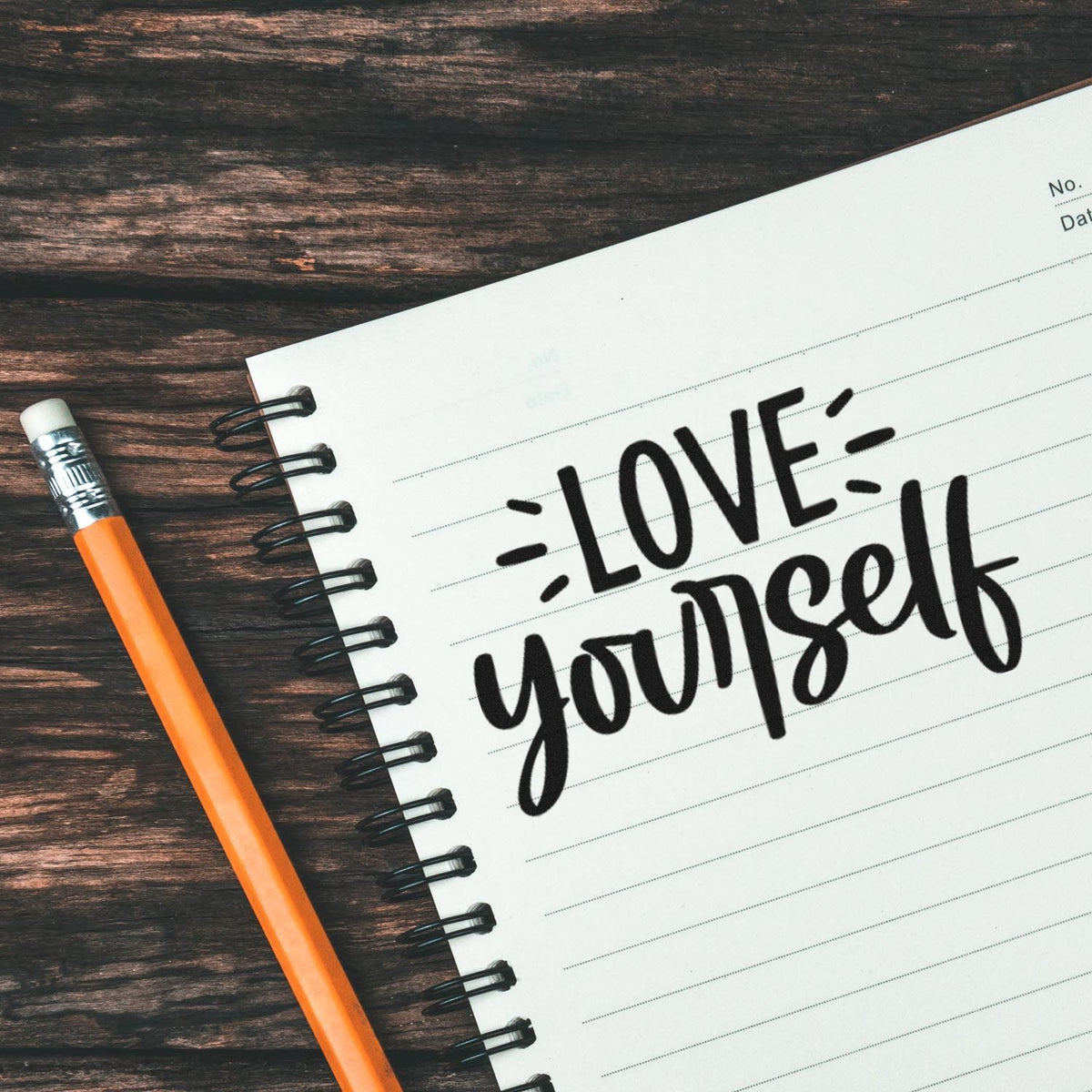 Love yourself motivational rubber stamp design on notebook page, perfect for self-care and positive journaling.