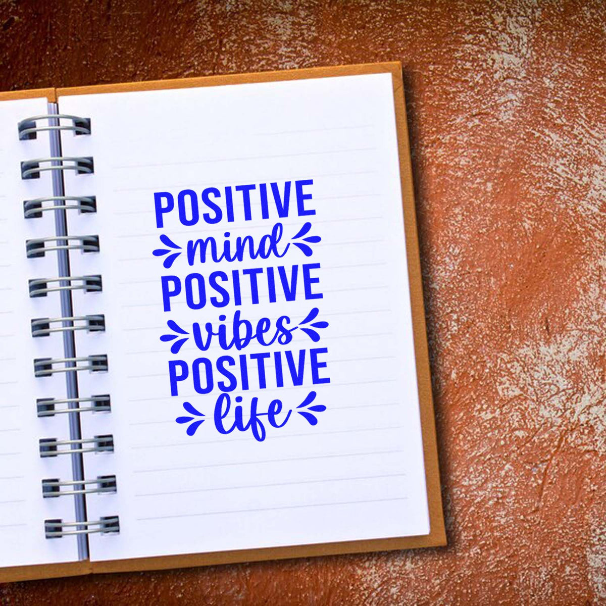 Positive mind, positive vibes, positive life inspirational rubber stamp quote on notebook page.