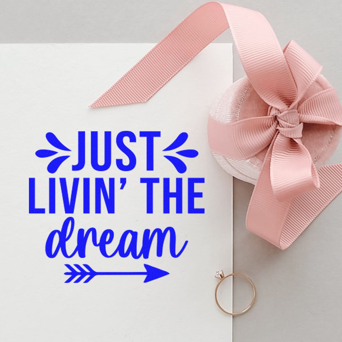 Custom rubber stamp design reading Just Livin the Dream on a pink ribbon gift card for handmade packaging.