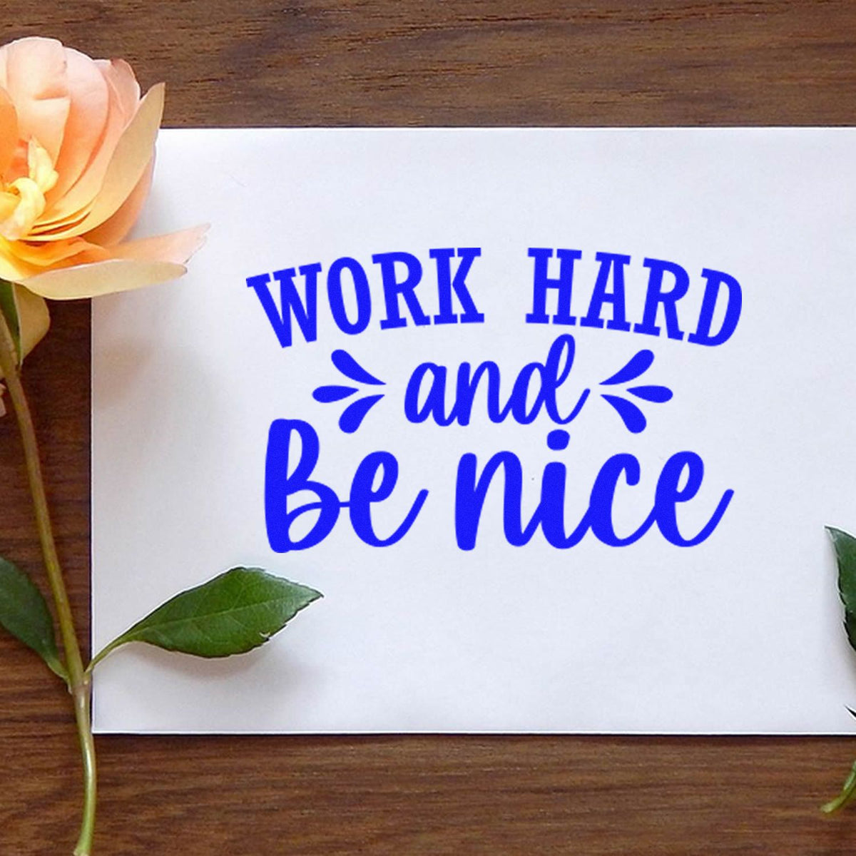 Motivational rubber stamp design reading Work Hard and Be Nice in blue ink on white paper, ideal for teacher or office crafts.