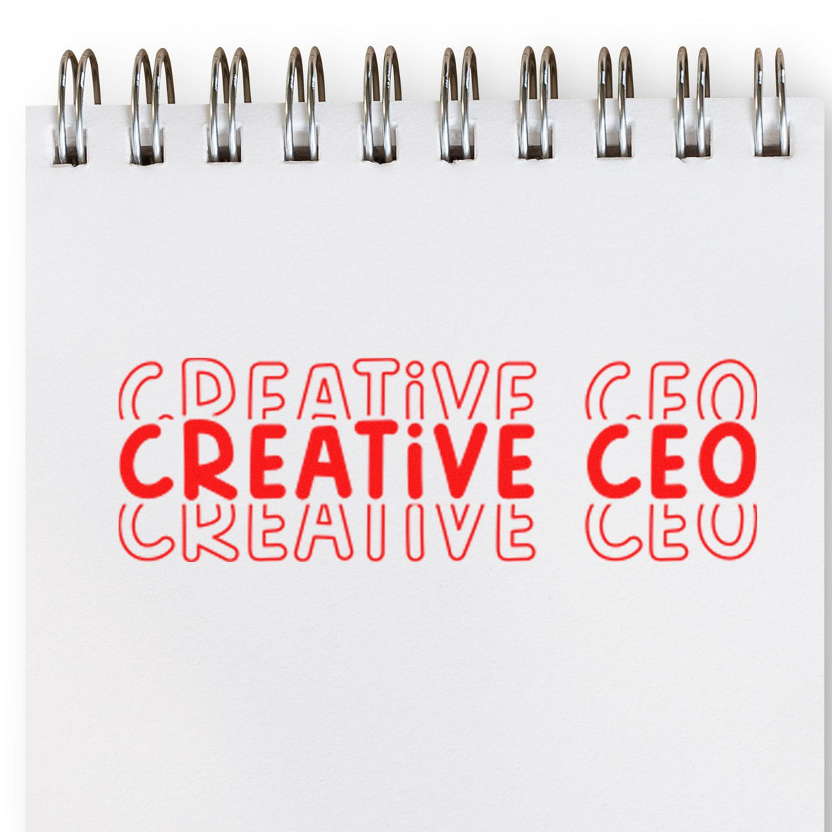 Creative CEO rubber stamp impression on spiral notebook page for custom business branding and office stationery.